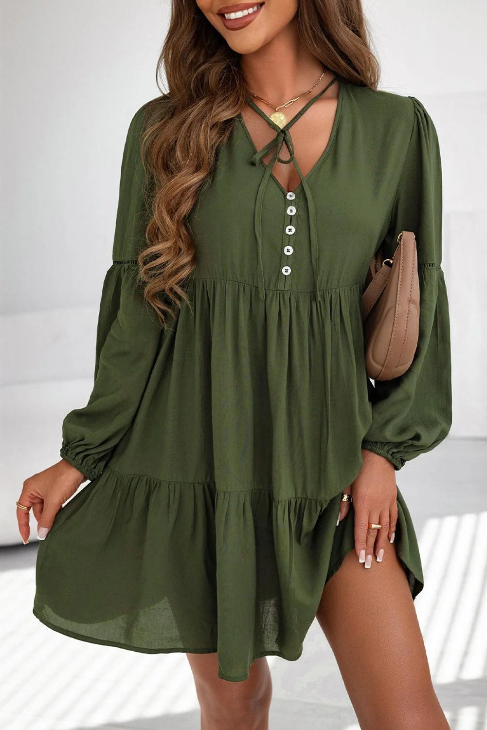 Green tiered mini dress with button details, perfect for casual outings. Made from lightweight, breathable fabric for…