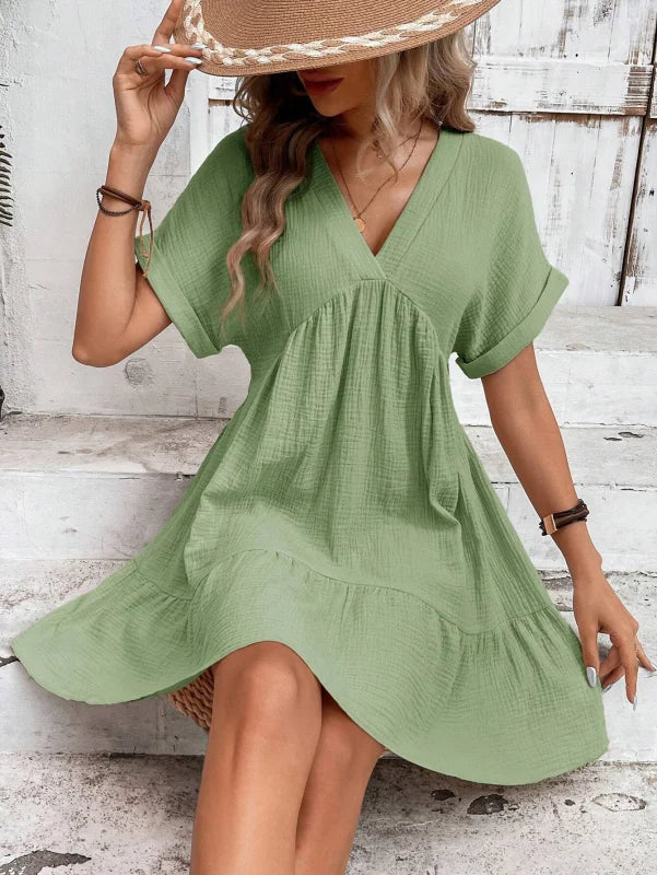 Flowy V-neck mini dress with pleated skirt in a light and airy fabric, perfect for a chic and effortless look.