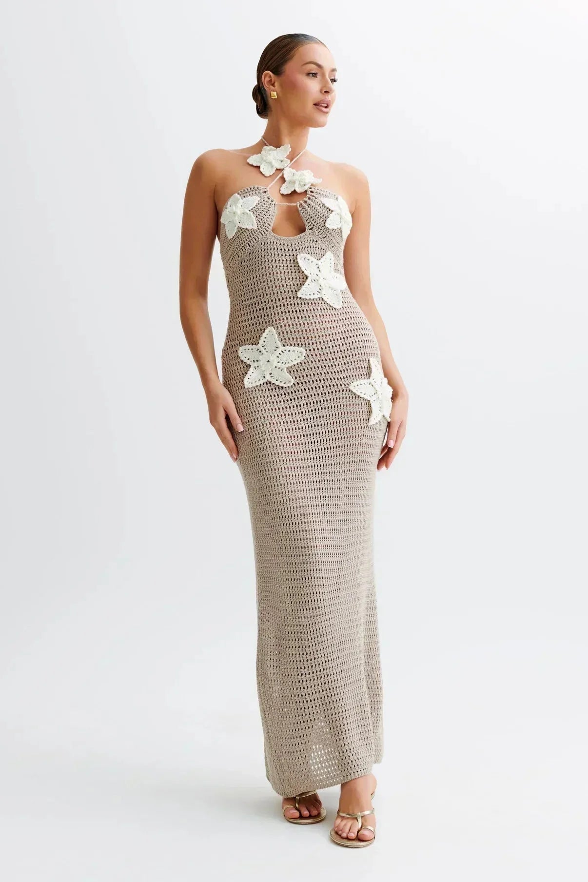 Crochet maxi dress in white with intricate floral accents, perfect for a bohemian summer look.