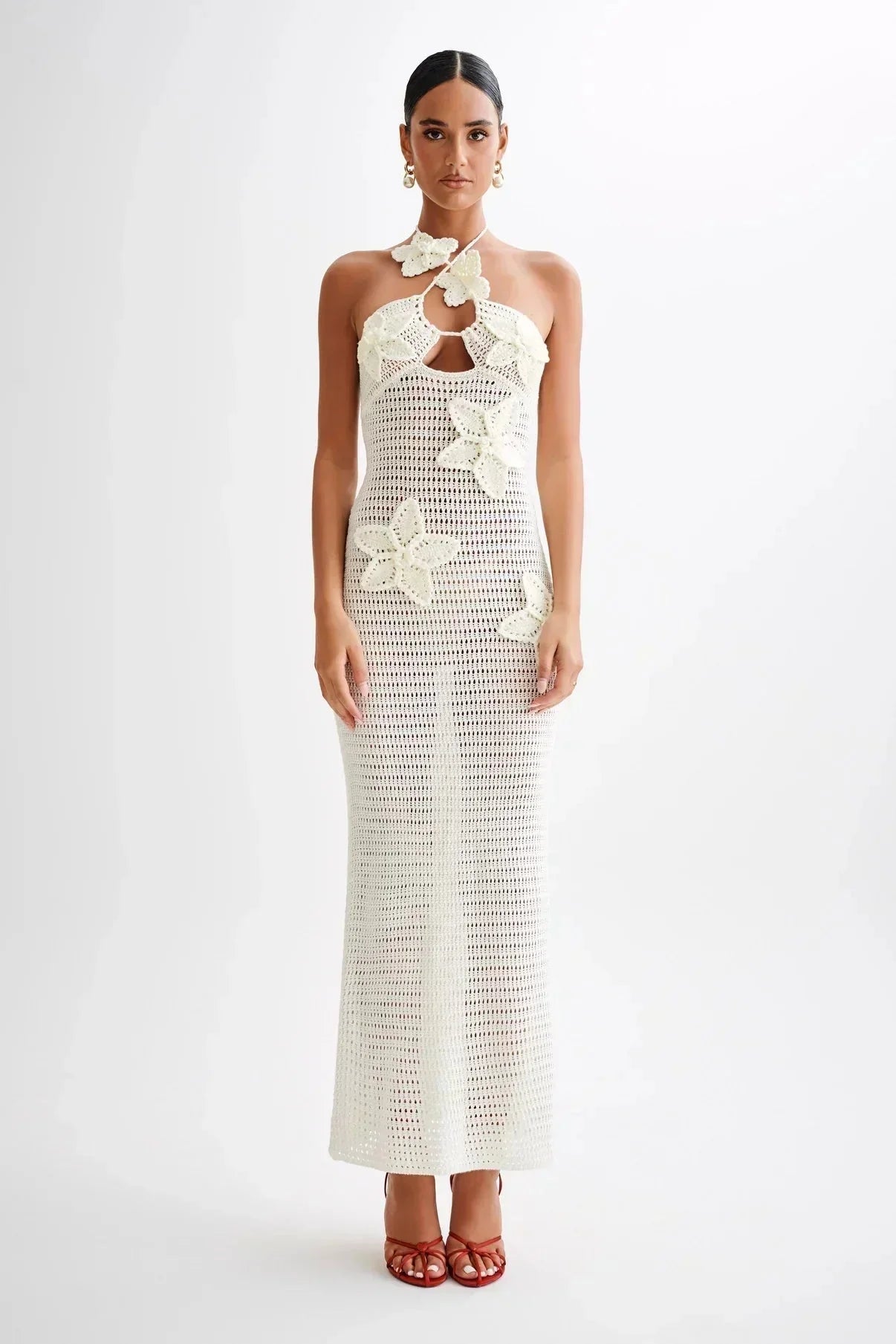 White crochet maxi dress with delicate floral accents, perfect for a chic summer look.