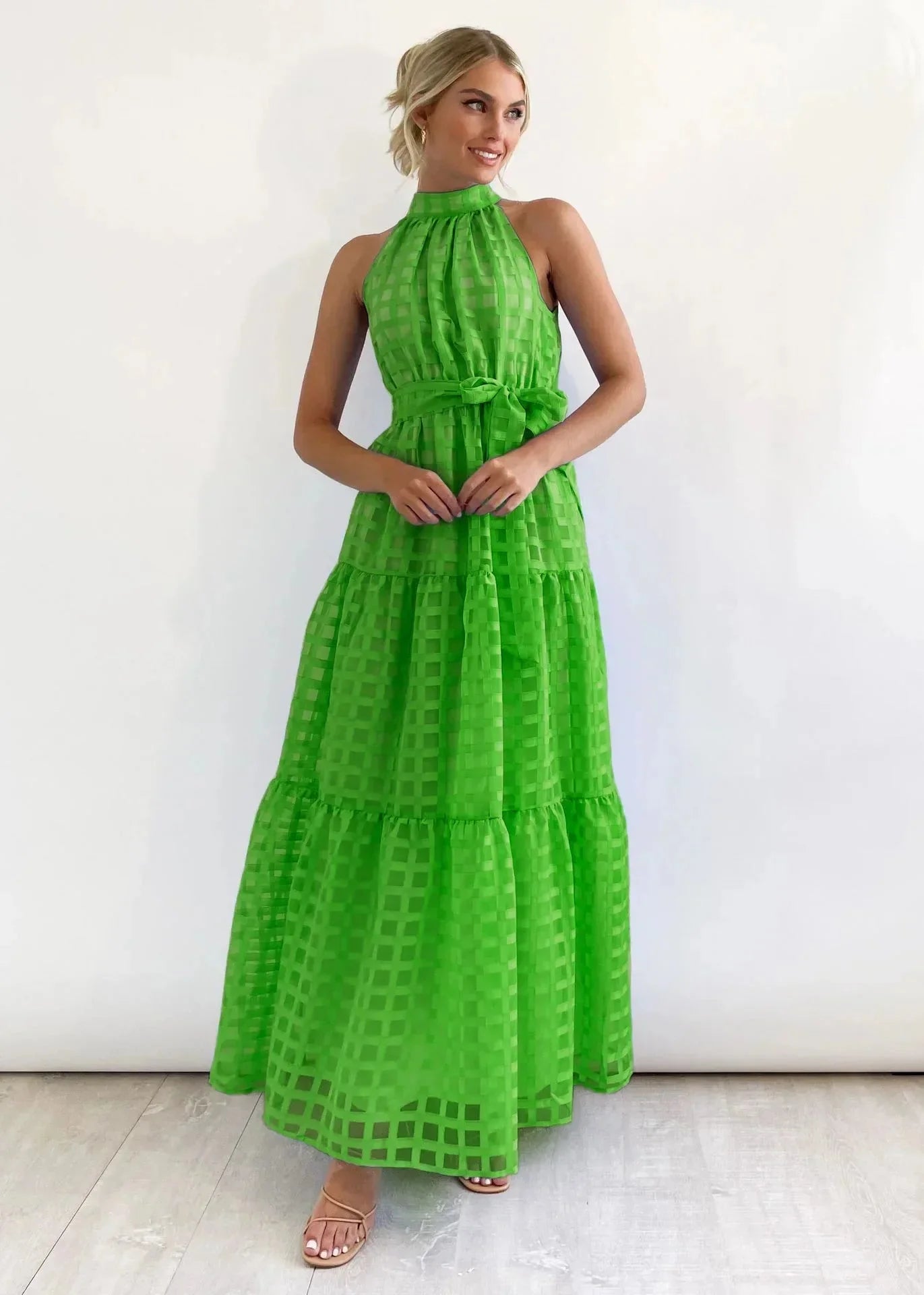 Green tiered halter neck summer dress, featuring lightweight and breathable fabric perfect for warm weather.