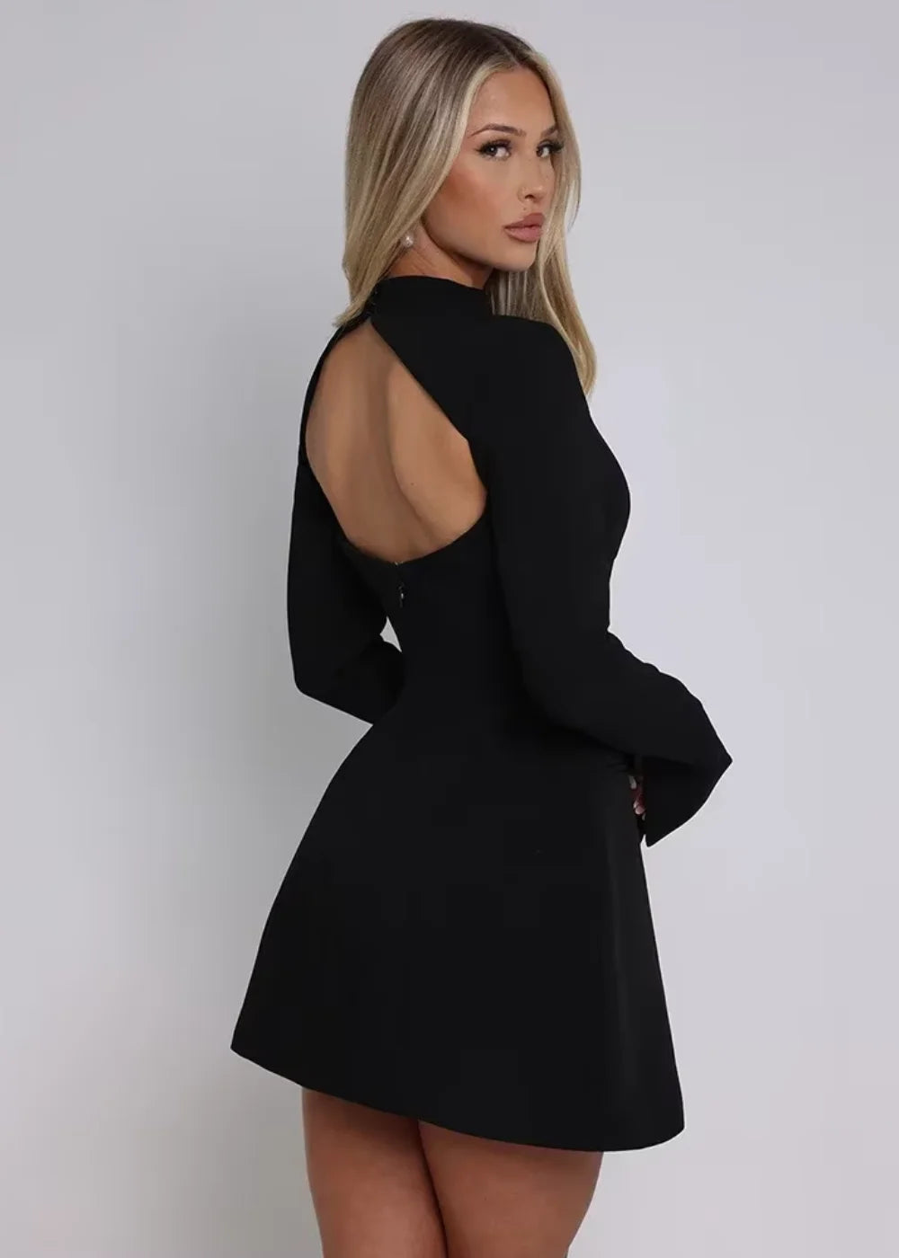 Black mini dress with flare design, featuring an open back. Made of high-quality fabric, perfect for a formal yet modern…