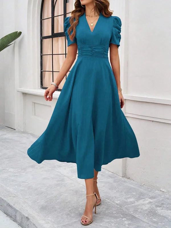 Blue midi dress with ruched waist, V-neck, and elegant design. Made of soft, stretchy fabric for a comfortable fit.