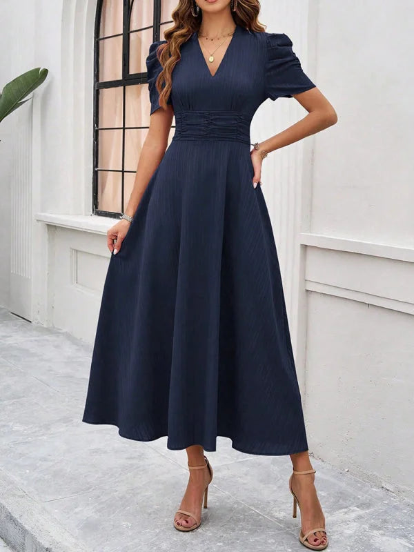 "Navy midi dress with ruched waist, V-neck, and elegant design, perfect for any occasion."