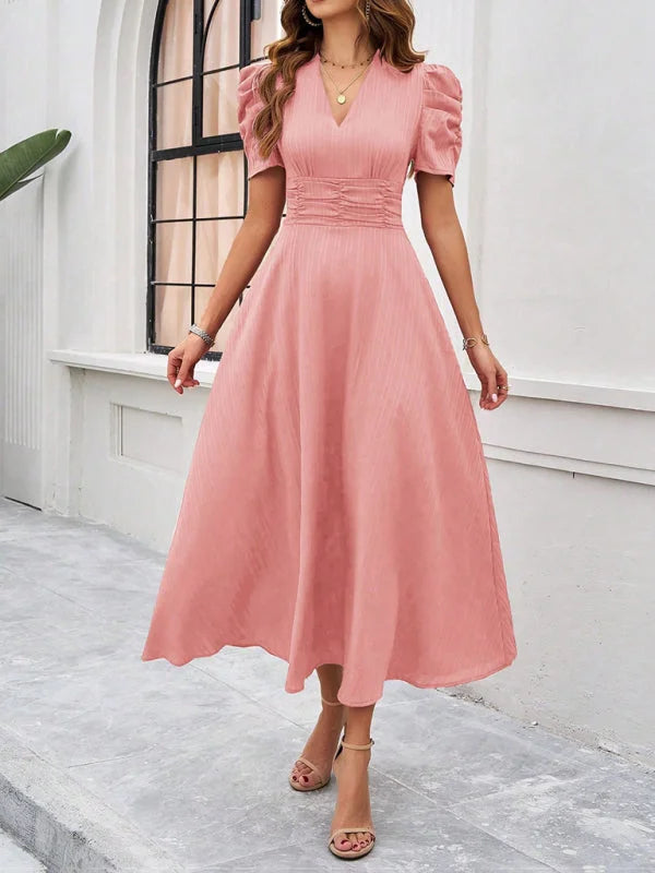 Pink V-neck midi dress with elegant ruched waist detail. Soft and flowy material, perfect for a variety of occasions.