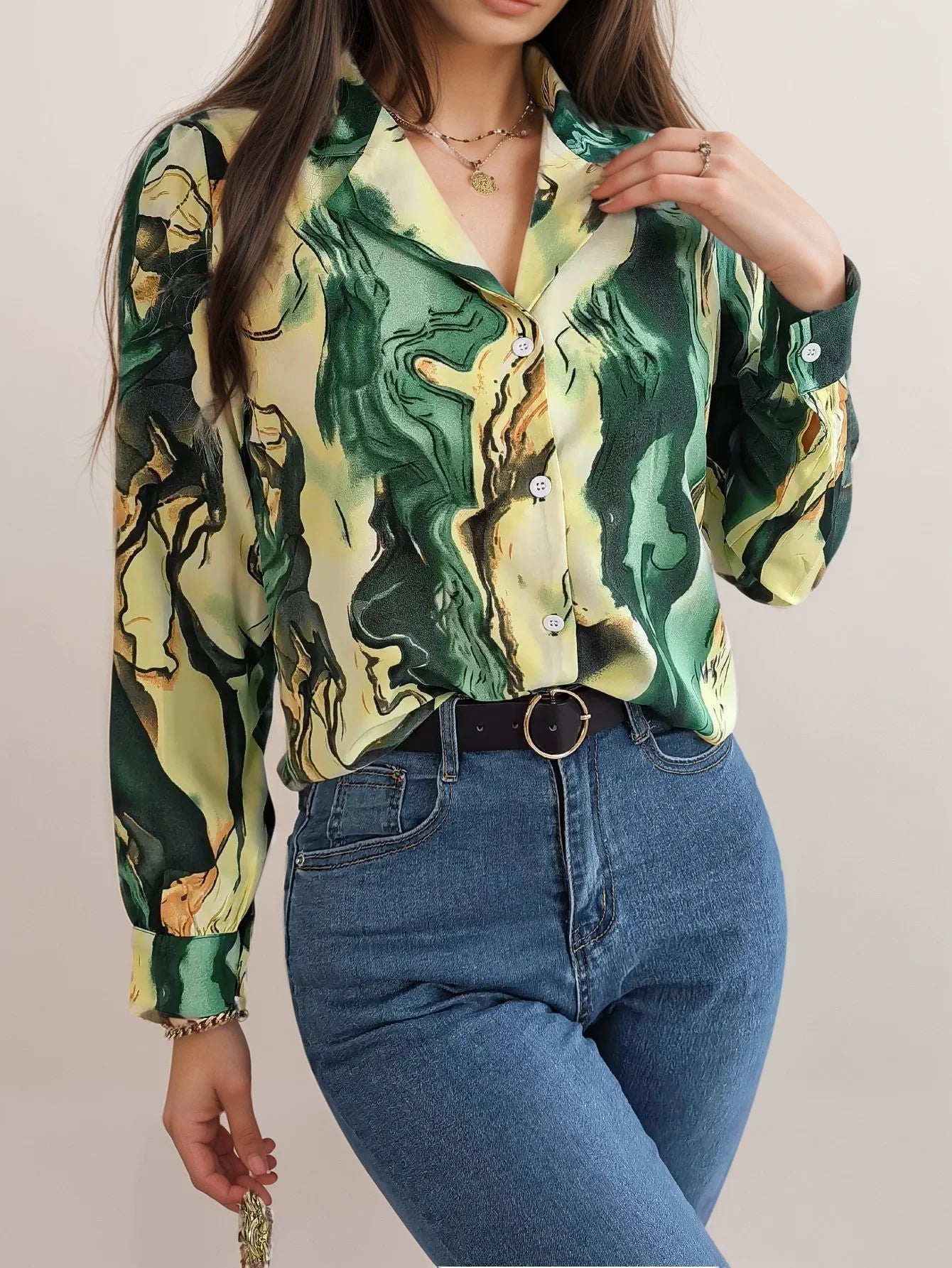 Green satin button-up blouse with abstract pattern, elegant silhouette.