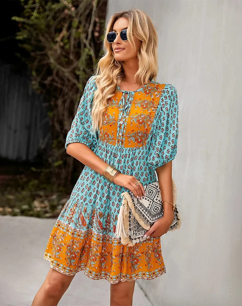 "Bohemian patchwork midi dress with vibrant mix of prints and textures in soft, flowy fabric for a free-spirited look."