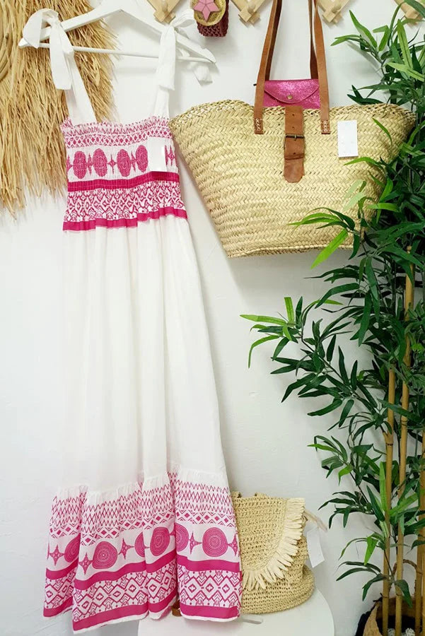 White maxi dress with pink accents, featuring a flowy silhouette and delicate design, perfect for summertime events and…