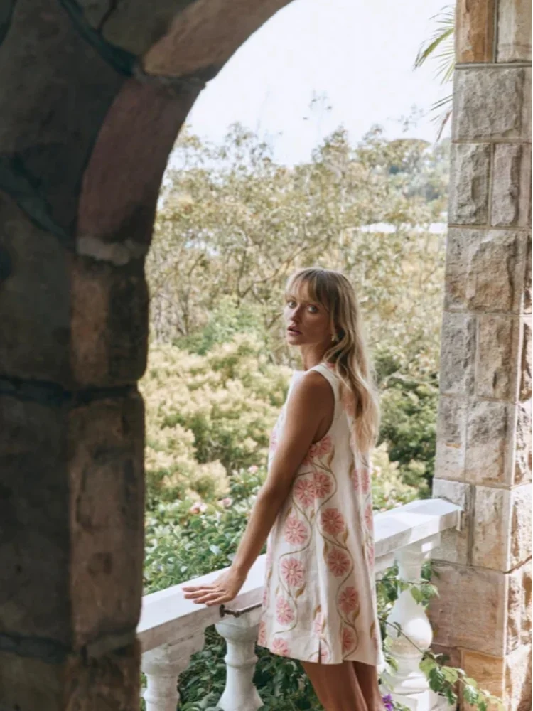 Sleeveless pink mini dress with floral print, perfect for a sunny day out.