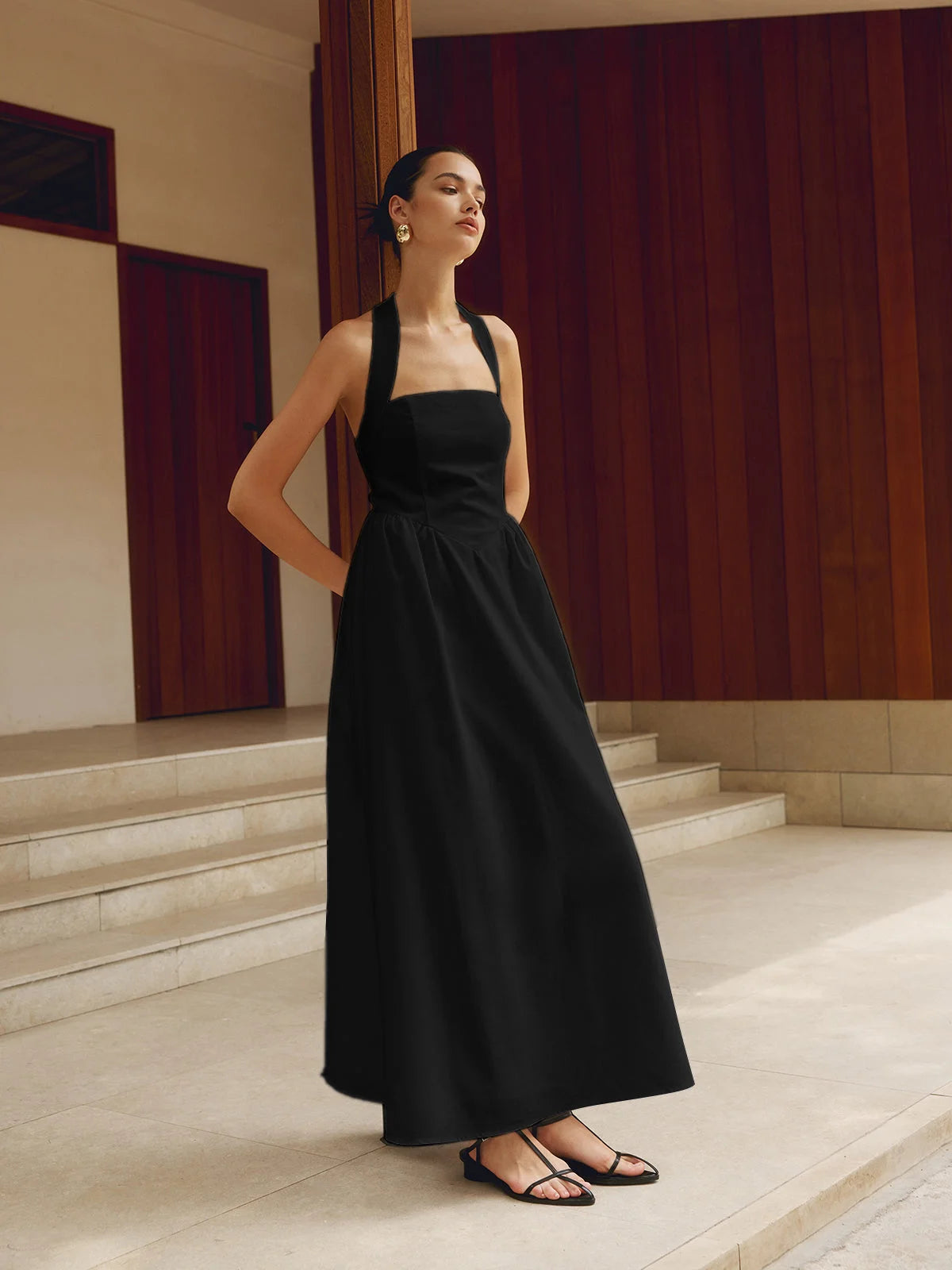 Black flowy halter neck A-line maxi dress with a lightweight fabric for a comfortable and stylish look.