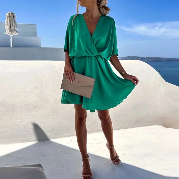 "Green flowy summer dress for women by Aven, made of lightweight linen blend with a flattering wrap design and adjustable…