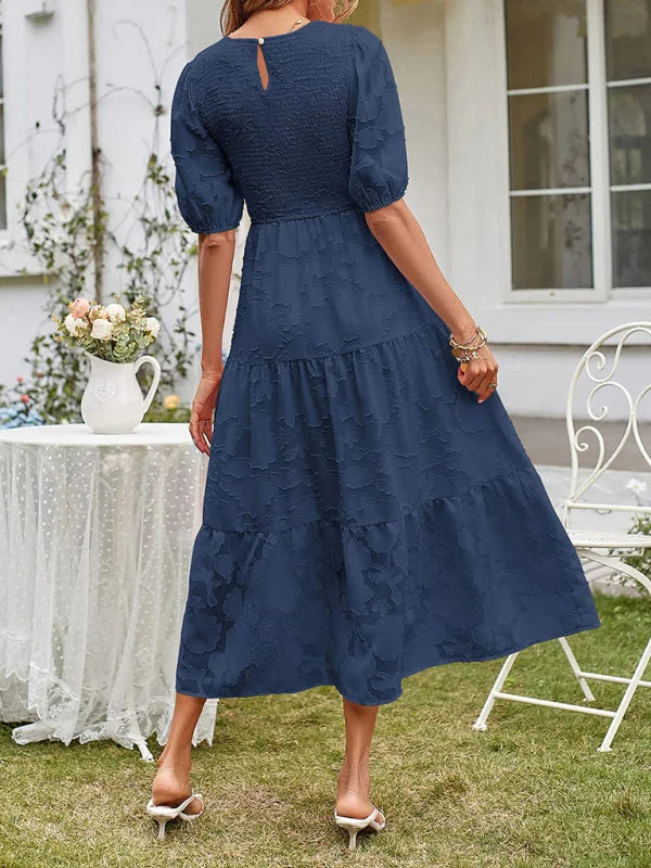 "Blue tiered midi dress with textured fabric detailing and a flattering silhouette."