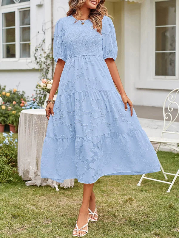 Blue tiered midi dress with textured fabric. Flowy design with subtle details. Perfect for a casual yet stylish look.