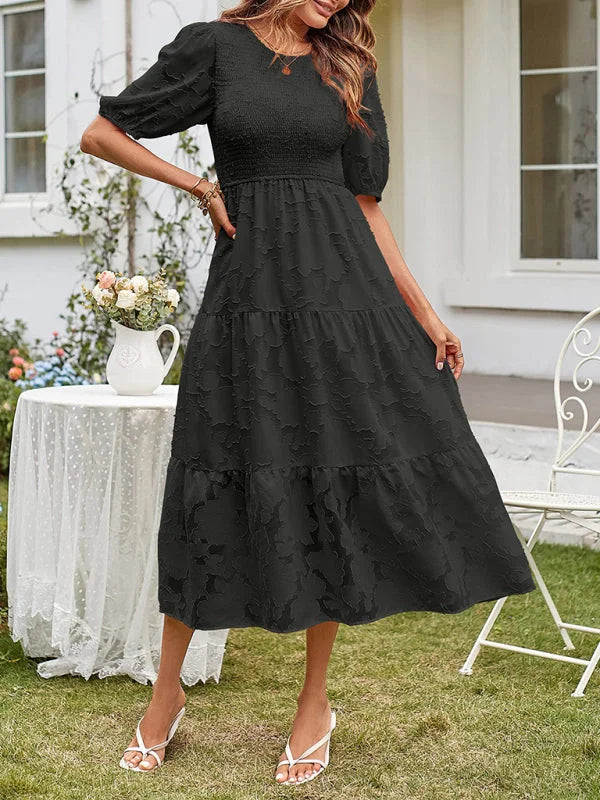 Black tiered midi dress with textured details; featuring a lightweight and flowy fabric perfect for any occasion.