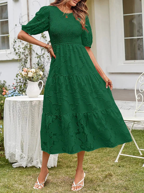 Green tiered midi dress with textured detailing, perfect for a casual yet stylish look. Made from a soft and breezy fabric.