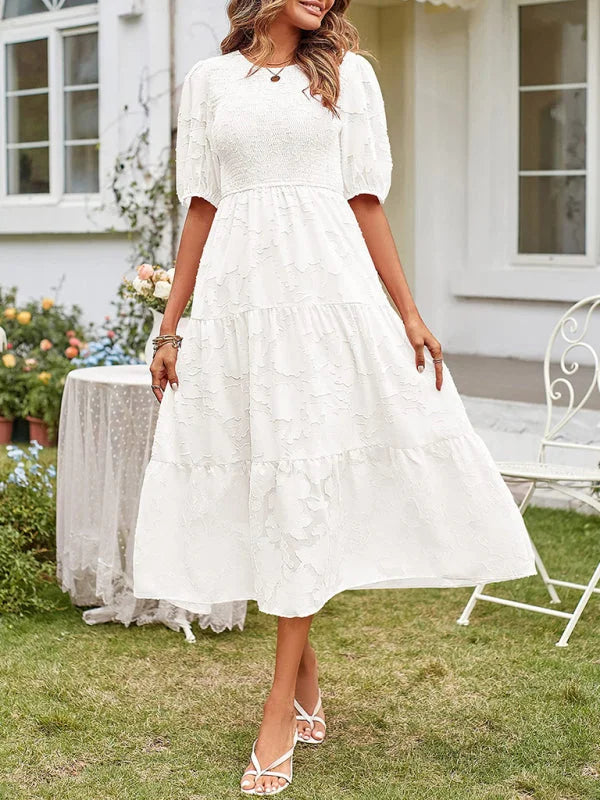 White tiered midi dress with textured details, perfect for summer.