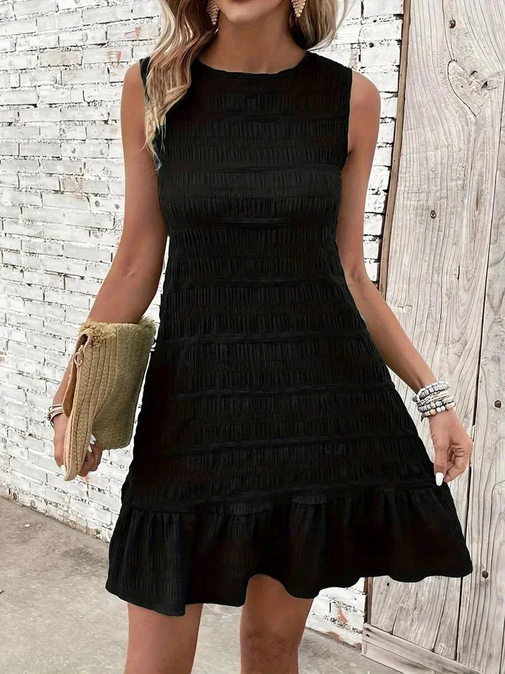 "Sleeveless black dress with textured fabric and ruffle hem, perfect for chic and stylish everyday looks."