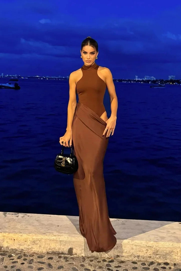 Sleeveless halter neck dress with side slits in a flowing fabric, perfect for summer days and special occasions.