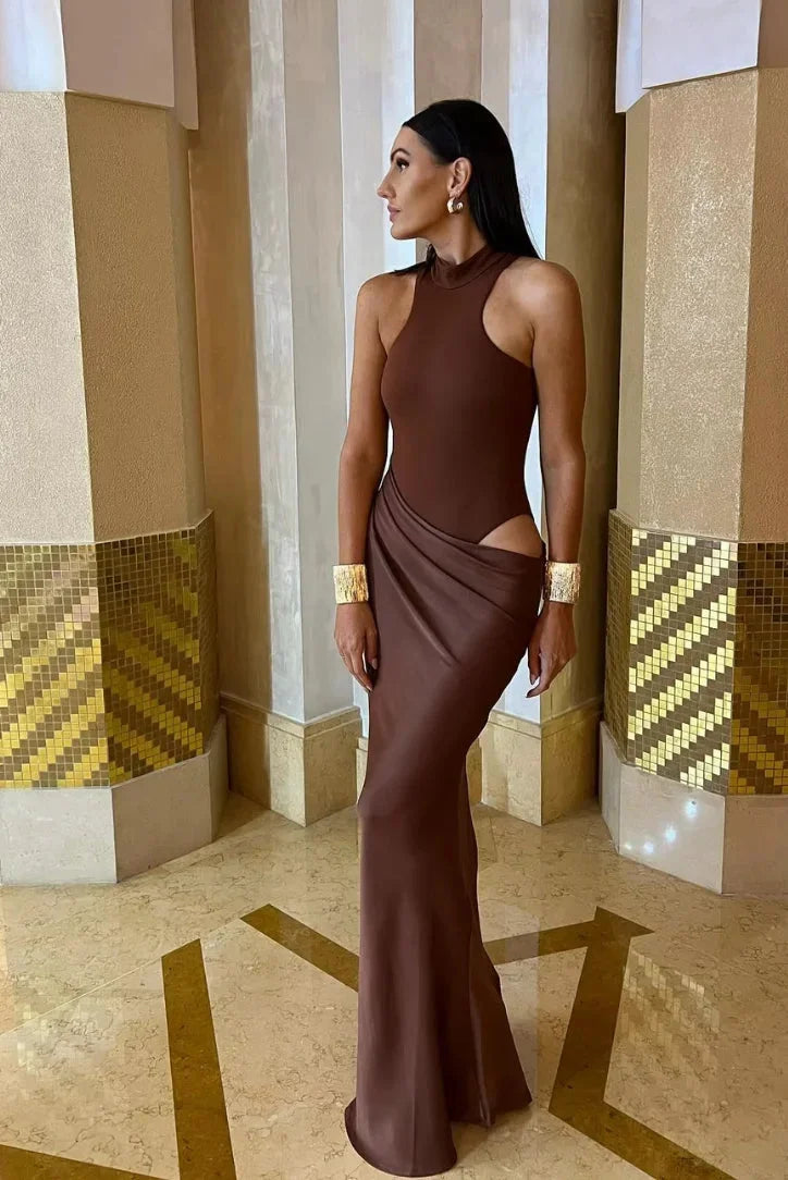 "Sleeveless halter neck dress with side slits in a flowing fabric, perfect for a modern and effortless look."