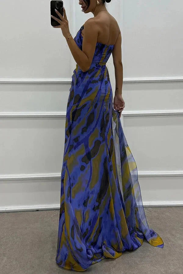 Women’s maxi dress in black with front slit, featuring intricate floral design accent.