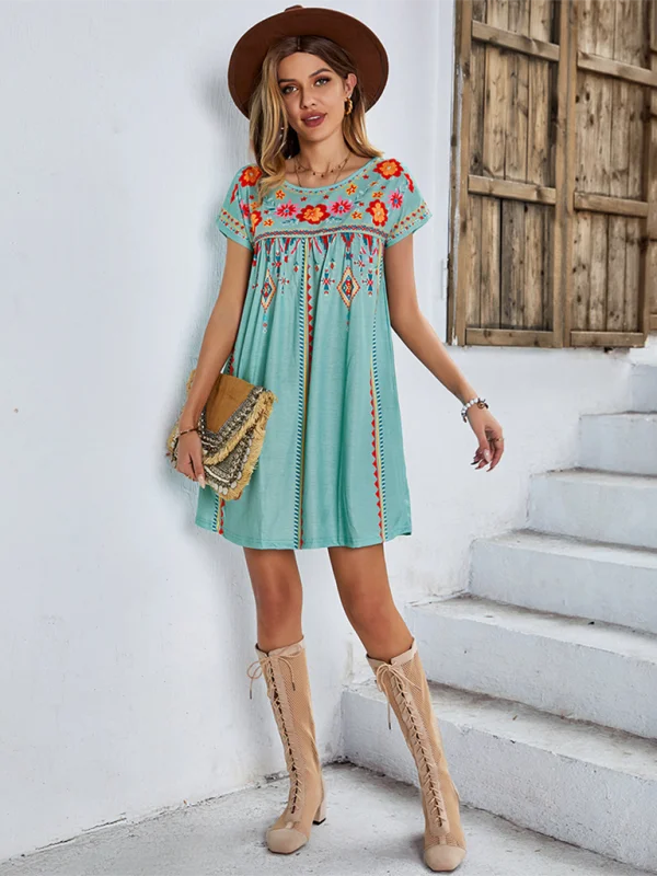 Bohemian dress with colorful floral embroidery, featuring a flowy chiffon fabric and off-shoulder design inspired by…