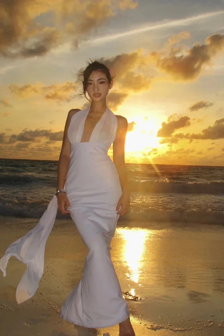 White halterneck maxi dress in fitted style, featuring a sleek design with a flattering silhouette.