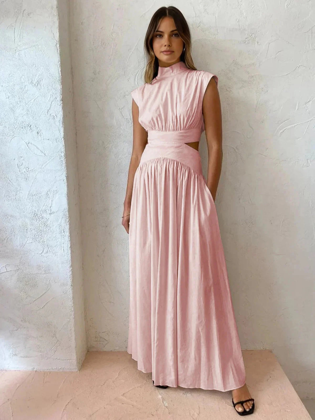 Pink sleeveless mock neck dress with cutouts by Cristel. Features a sleek and modern design perfect for any occasion.