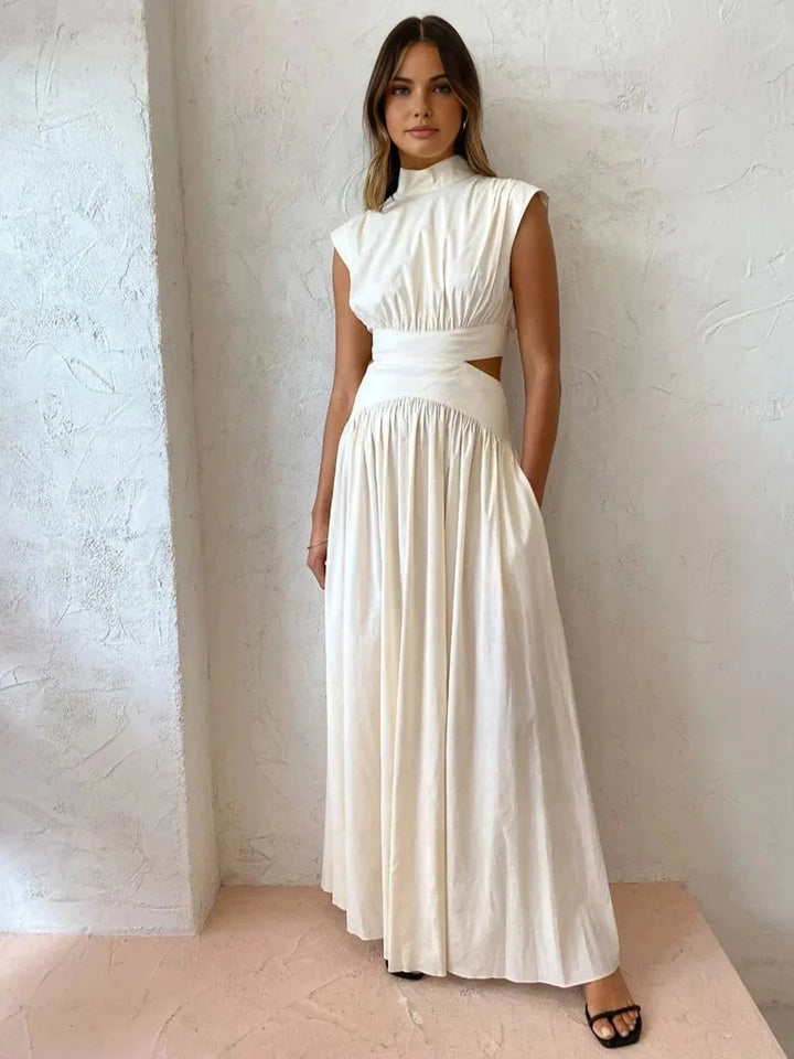 White sleeveless mock neck dress with cutouts by Cristel. Features a sleek and modern design perfect for a chic and stylish…