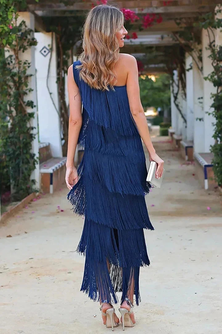 Women's flowy asymmetrical dress with fringe in soft, lightweight fabric. Unique design with playful fringe trim.