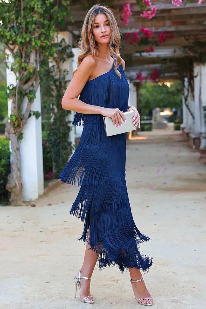 Women's black flowy asymmetrical dress with fringe detail, perfect for a bohemian look.