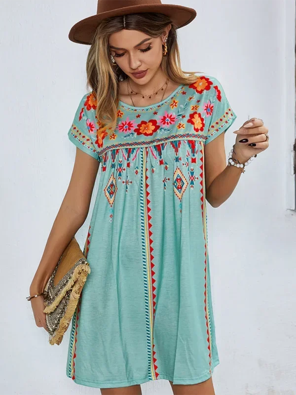 White embroidered boho dress with loose fit, featuring delicate floral patterns and airy fabric.