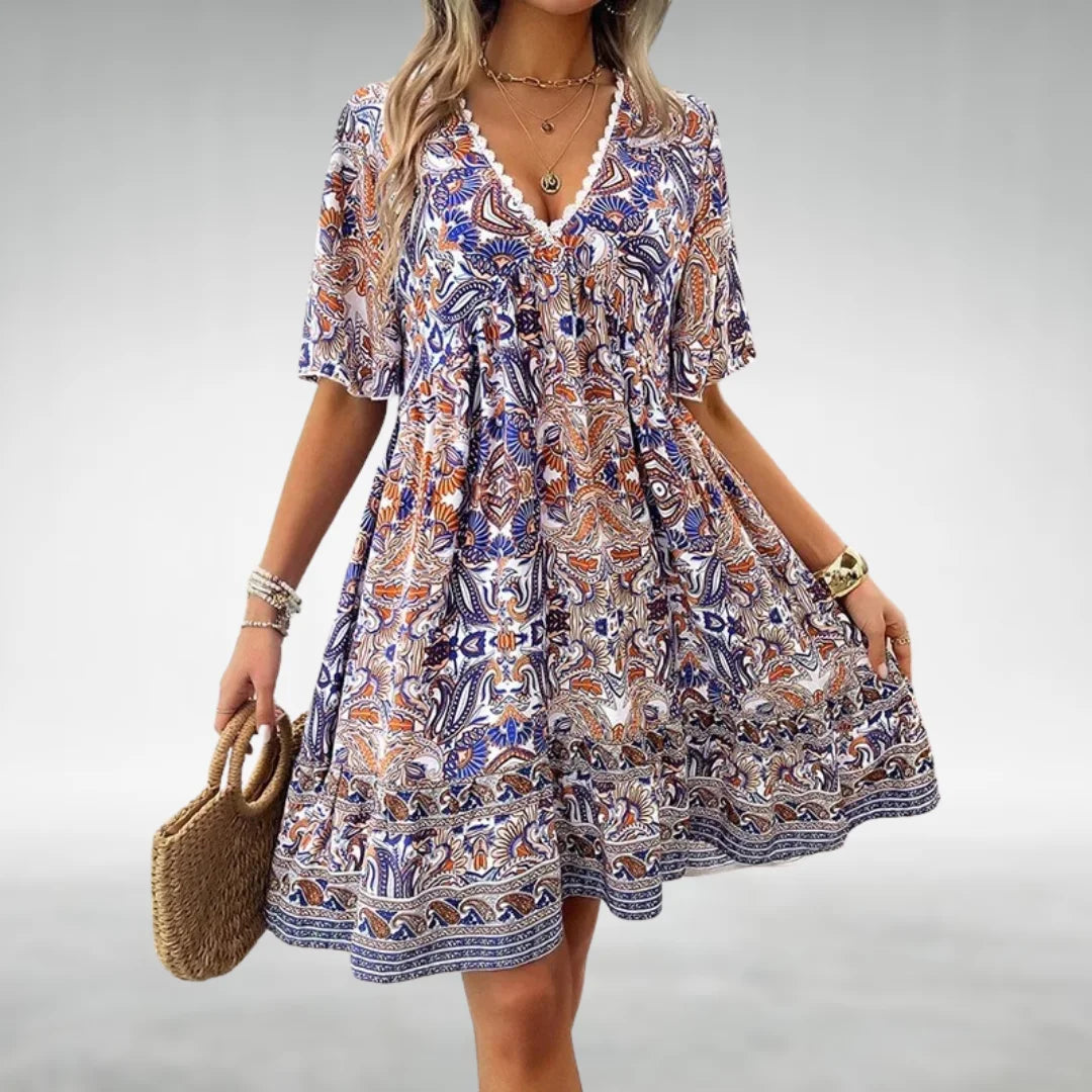 Blue paisley-patterned dress with bohemian style, made from soft organic cotton blend. Perfect for casual chic summer vibes.