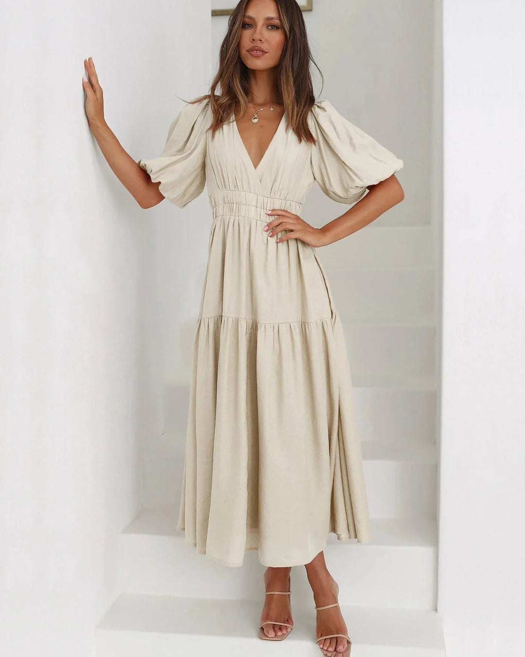 Cream flowy dress with puff sleeves, elastic waistband, and soft fabric material. Ideal for a casual, relaxed look.