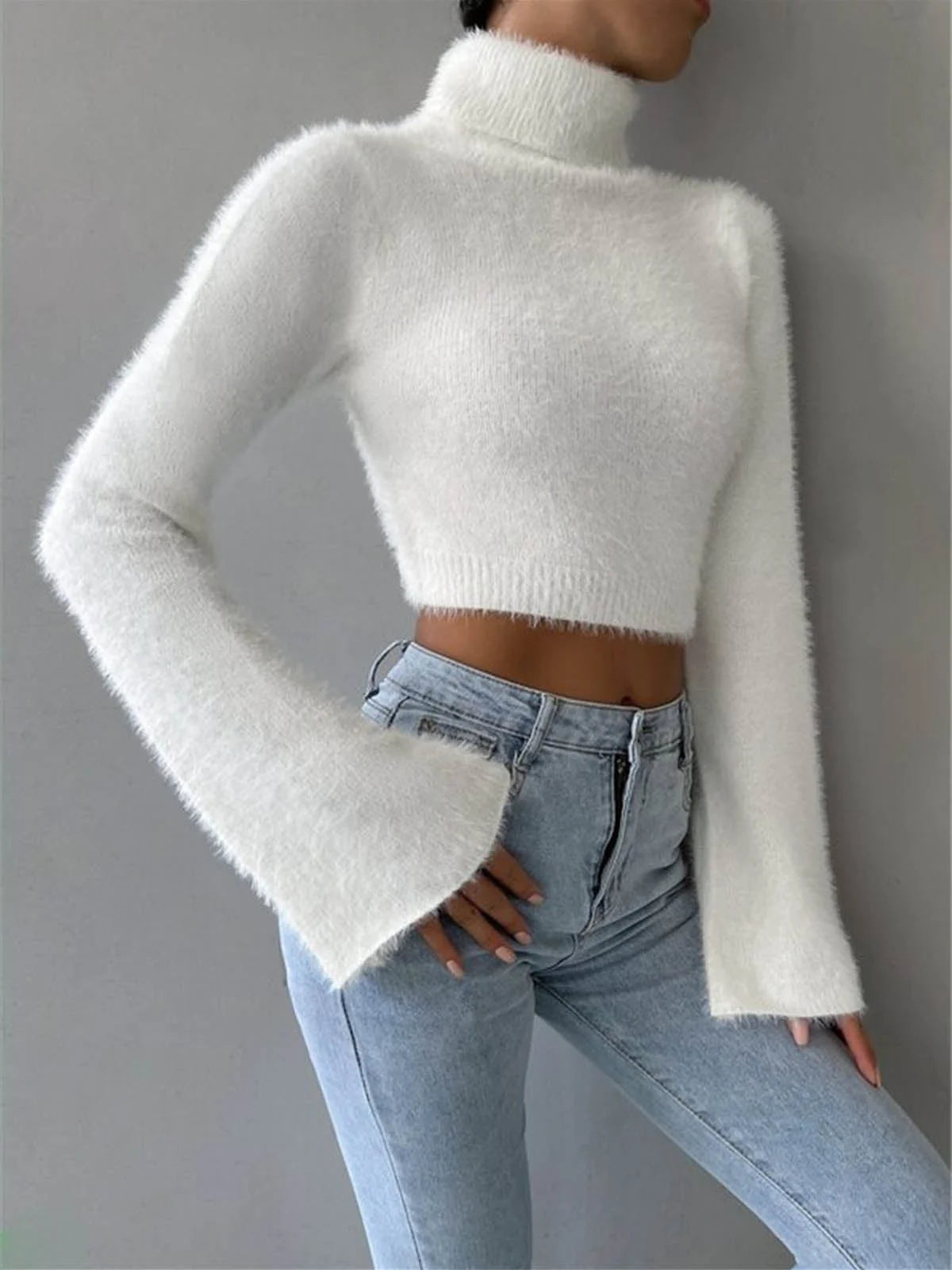 White cropped high neck fluffy sweater made of soft ribbed fabric with chunky knit detailing on the sleeves.