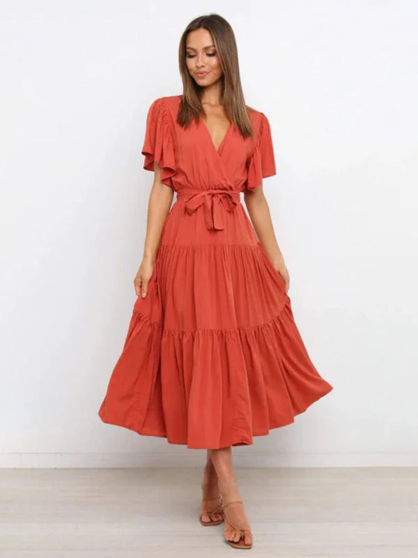 Orange midi dress with belted waist and flutter sleeves. Made from lightweight fabric, perfect for a casual chic look.