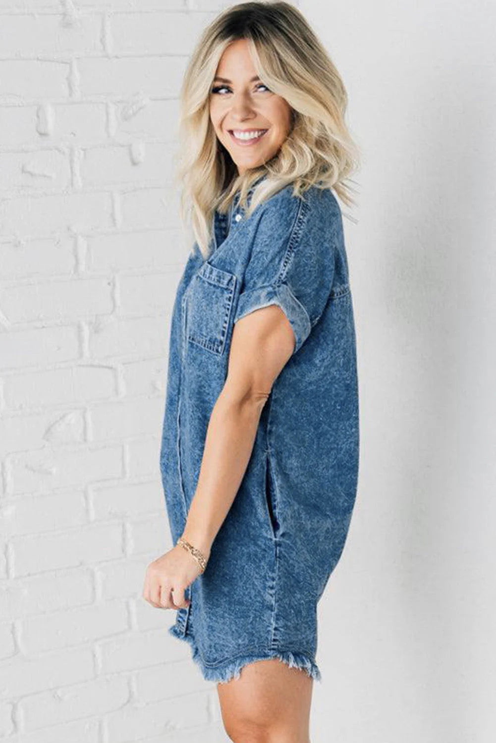 Denim button-up mini dress with frayed hem, casual-chic style perfect for laid-back outings or easy weekends.