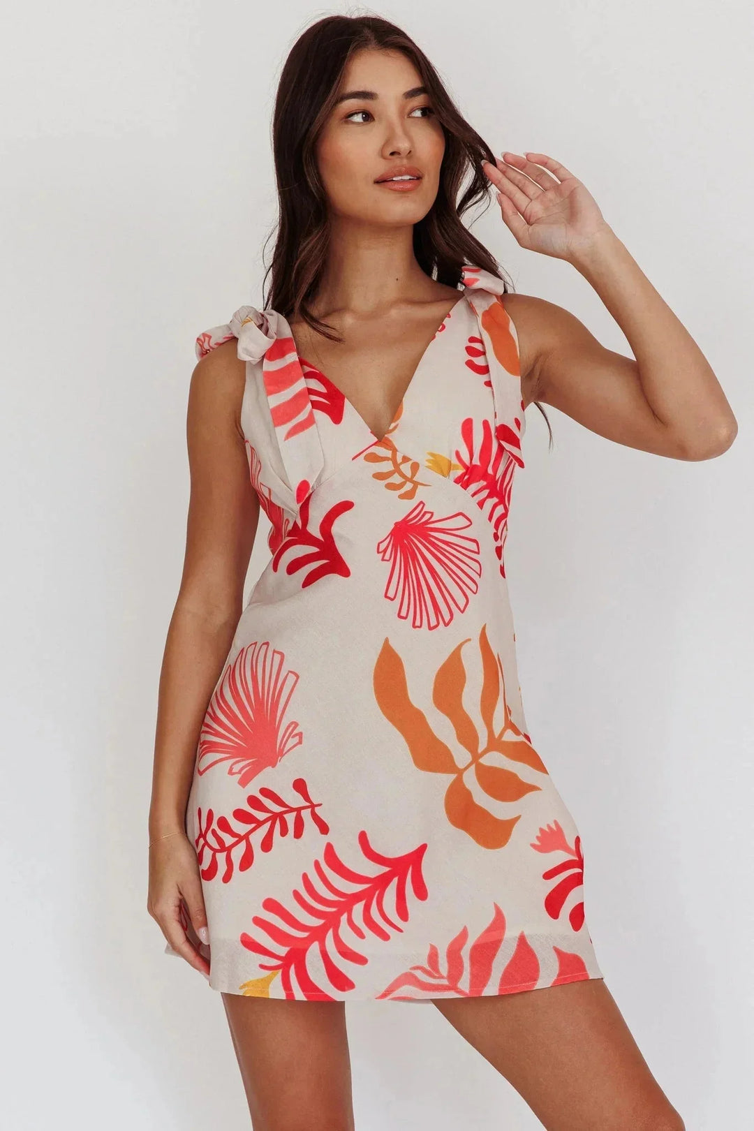 White mini dress with orange floral print, made of soft cotton blend. Features a flattering fit for women, perfect for…