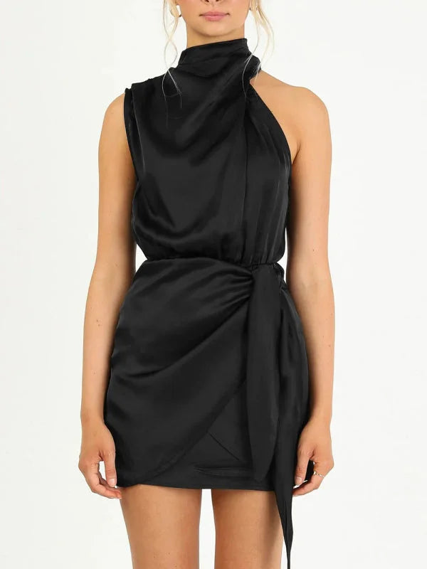 Black mini dress with halter neck, draped front, and tie waist, made from soft and flowy fabric.