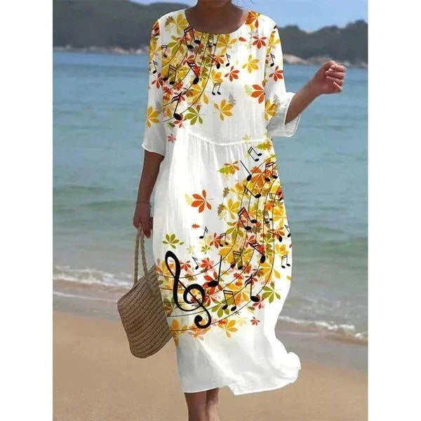 White midi beach dress with green floral print and leaf design. Perfect for a day at the beach or a summer picnic.