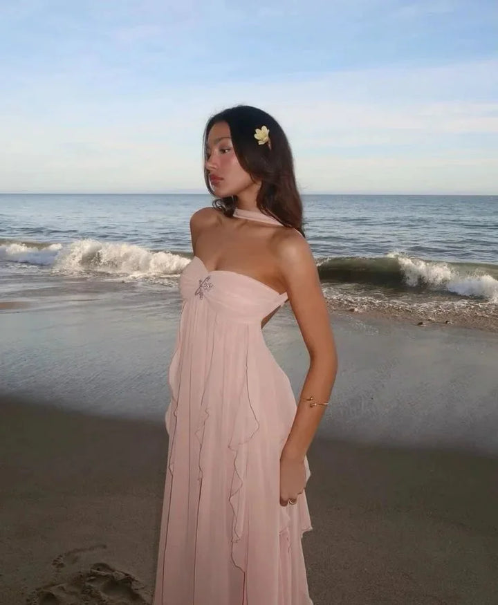 Pink strapless maxi dress with flowing ruffles, ideal for a romantic evening. Made of lightweight and breathable fabric.