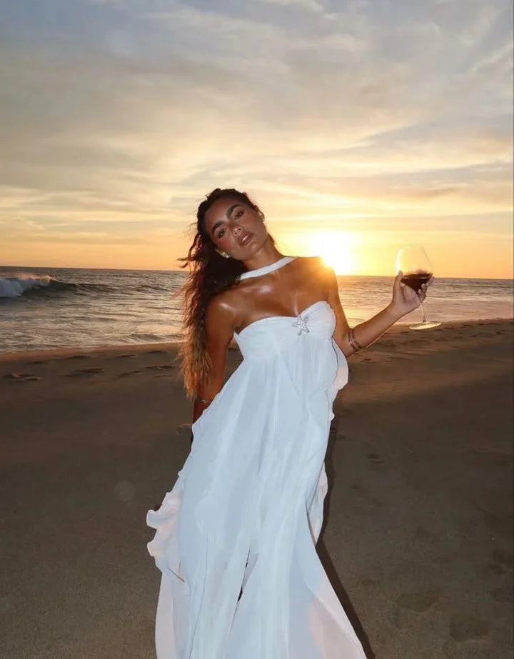 White strapless maxi dress with flowing ruffles, perfect for a summer day. Made with lightweight and breathable fabric for a…