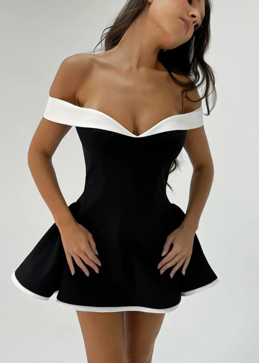 Off-shoulder mini dress in black with elegant white trim detail, perfect for a stylish summer look.