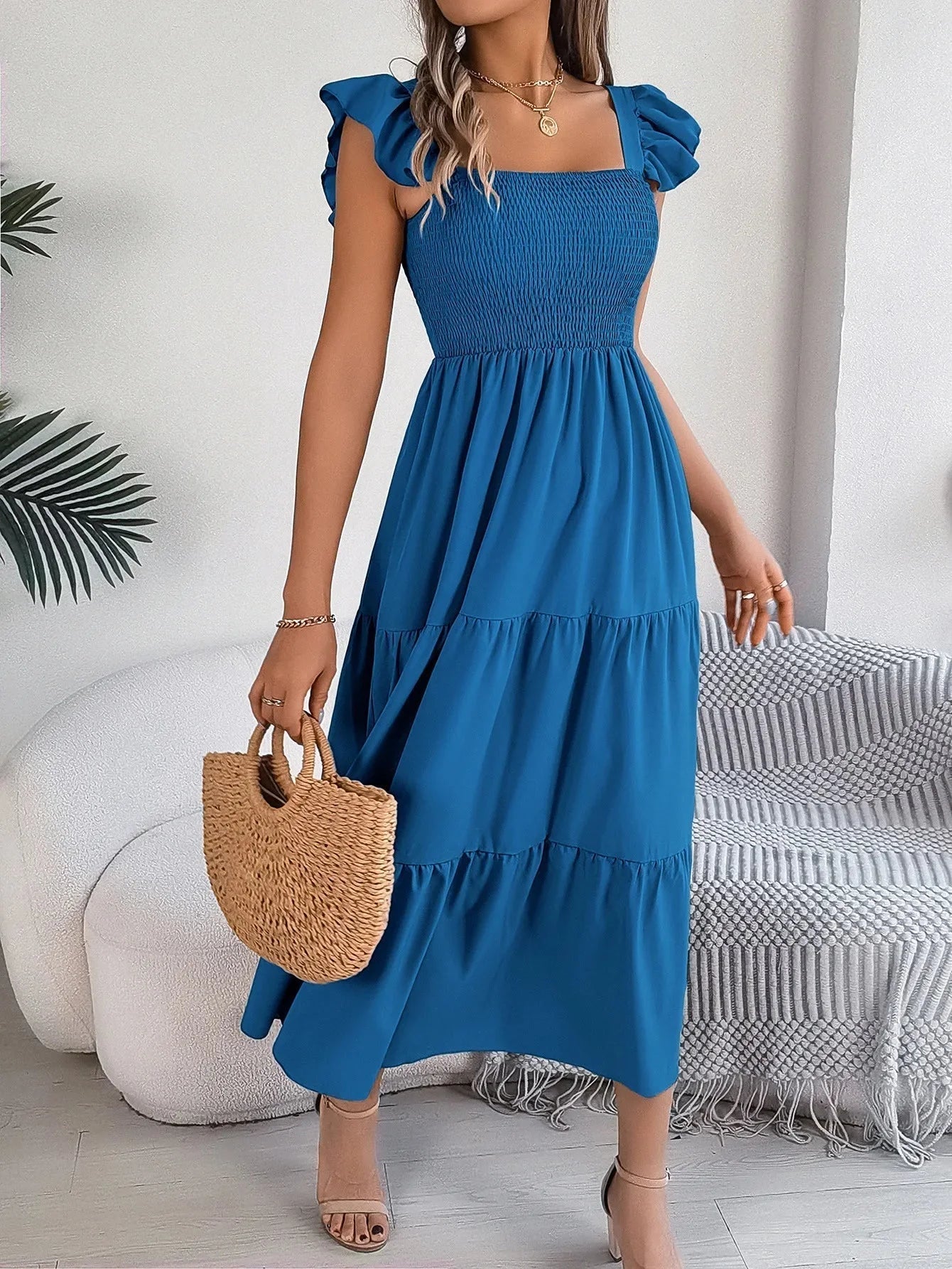 Blue smocked midi dress with tiered ruffle details. Elegant and stylish, perfect for casual outings or special occasions.