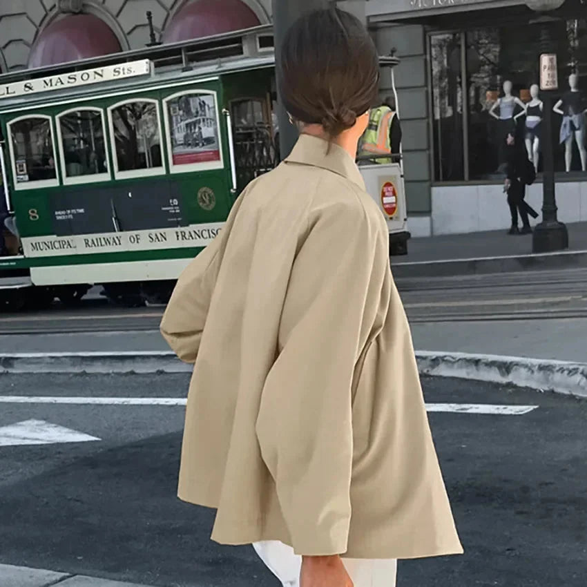 Beige oversized jacket with front buttons, featuring a relaxed fit and soft, textured fabric for a cozy and stylish look.