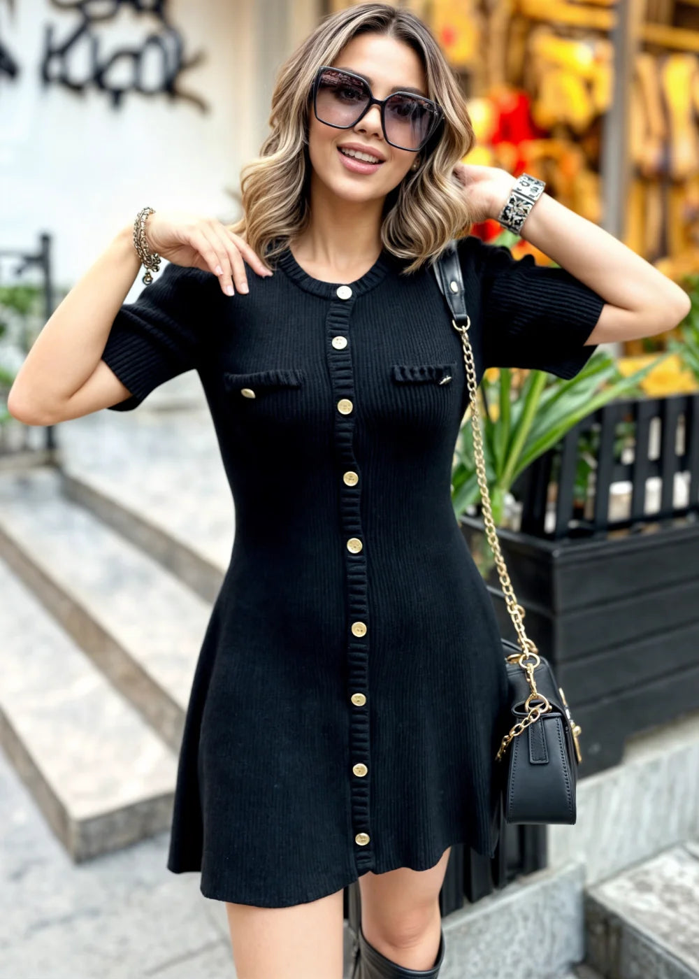 "Black flared skirt buttoned mini dress, made from soft cotton blend. Features V-neckline and short sleeves."