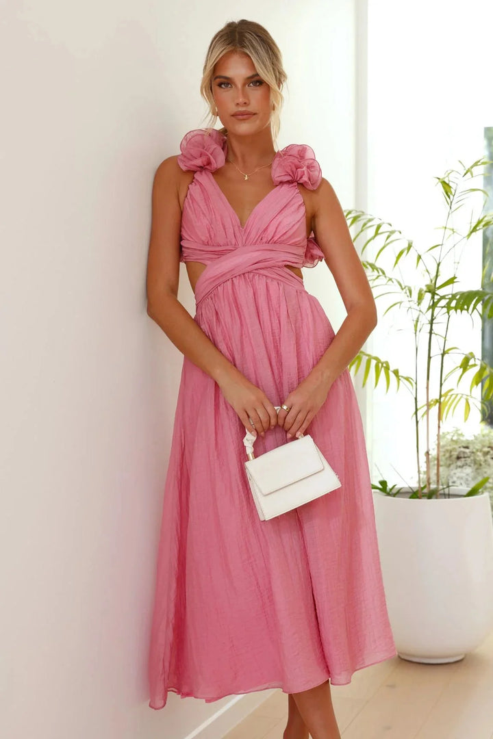 Pink midi dress with twisted bust detail, shoulder ruffles, and a flattering silhouette. Made of soft, flowy fabric in a…