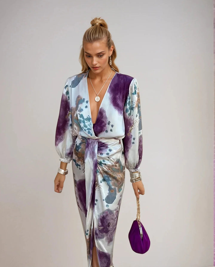 Women's satin wrap dress with artistic print featuring delicate floral patterns on a black background.