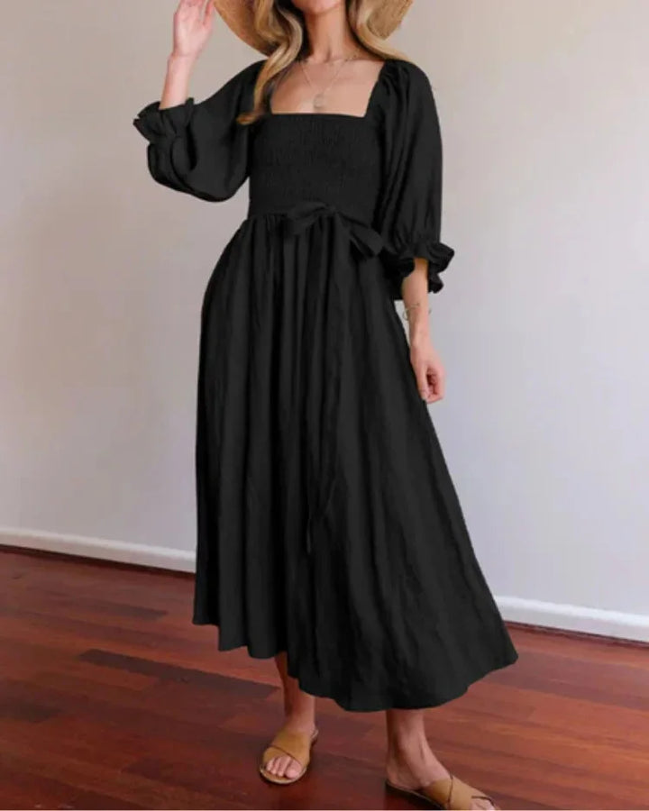 "Black wrap dress for women with ruched sleeves, made of soft and sleek fabric, perfect for casual or elegant occasions."