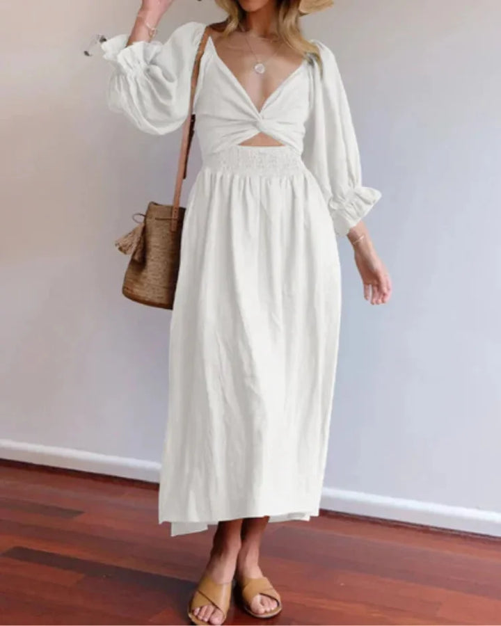 White wrap dress with ruched sleeves, made of soft flowy fabric. Flattering silhouette for women's fashion.