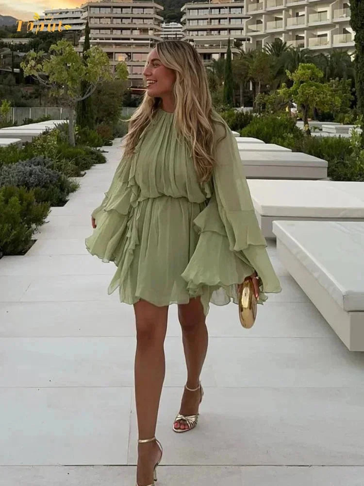 Sage green mini dress with tiered ruffles, flowy design, perfect for a casual day out or a special occasion.